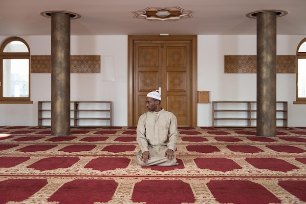 전통적인 모자 Dishdasha를 입고 신에게 전통적인 기도를 하는 아프리카 이슬람 남자