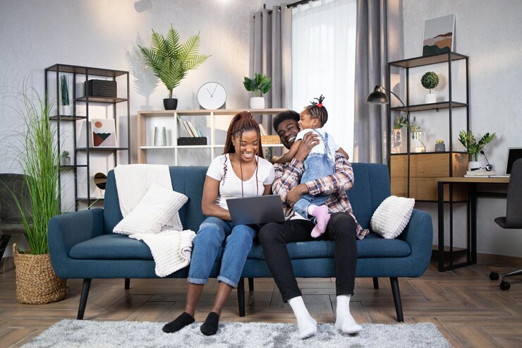 Photo african parents playing with daughter and using laptop
