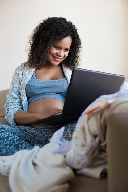 彼女の赤ちゃんのためにオンラインショッピングをしているアフリカの妊婦