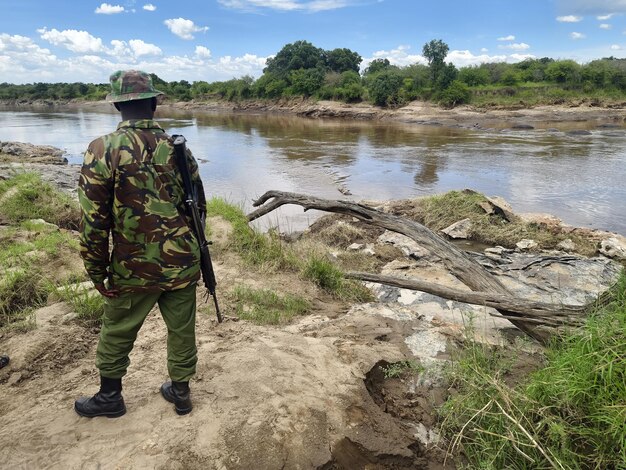 African soldier are walking along river bank tracking wild animals