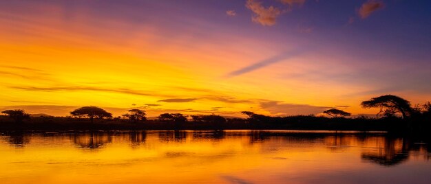 African sunset with a lake trees and mountains sunset by a water lake in the savannah south africa