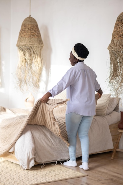 African woman in a bedroom with ethnic interior