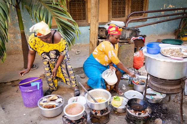 African woman cooking traditional food at street