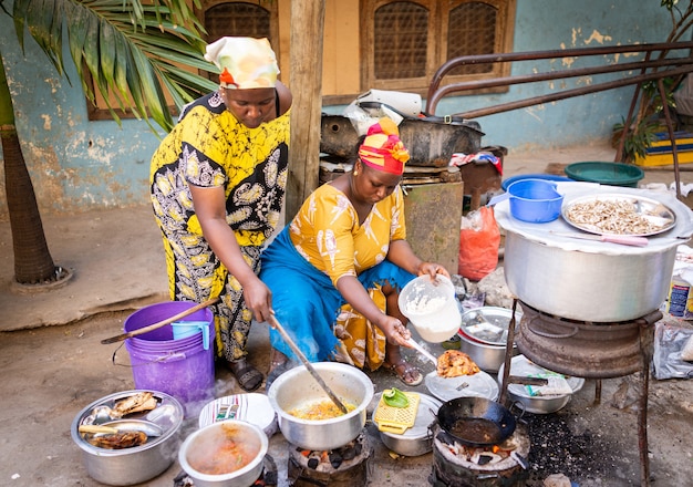 通りで伝統的な料理を調理するアフリカの女性