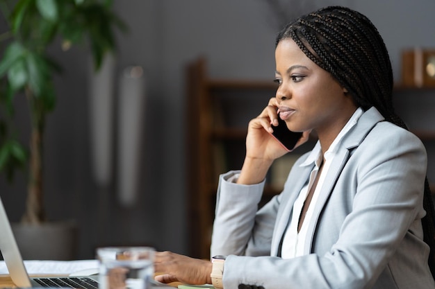 Premium Photo | African woman ecommerce business owner talking on mobile  phone running online store from home