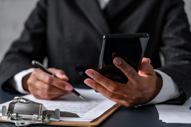 African woman hands with phone and contract