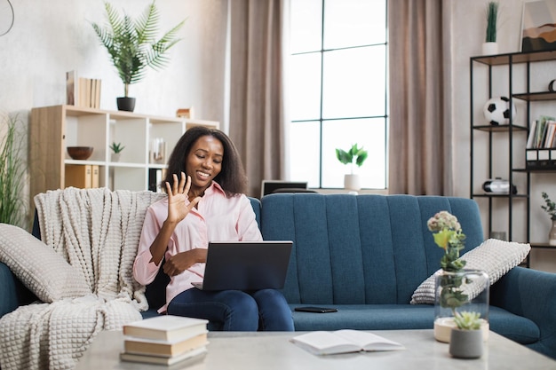 African woman having video call on laptop at home