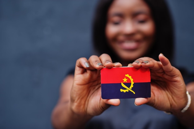 아프리카 여자 손에 작은 앙골라 국기를 들고
