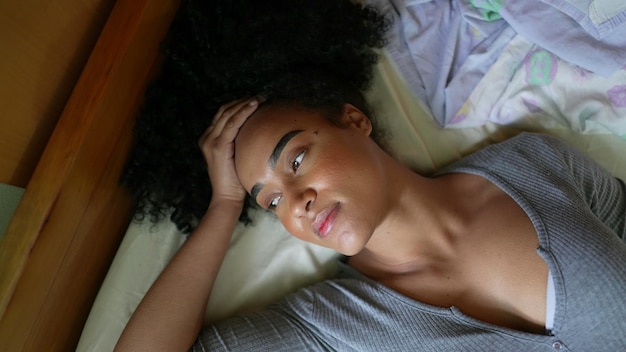 An African woman lying down in bed to rest