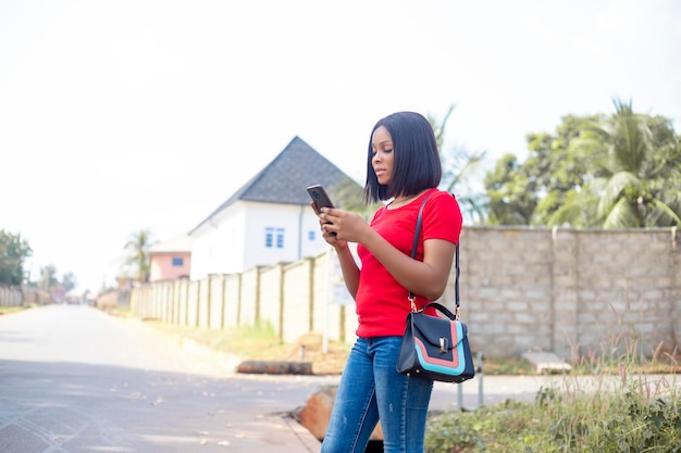 African woman ordering taxi cab using smart phone app