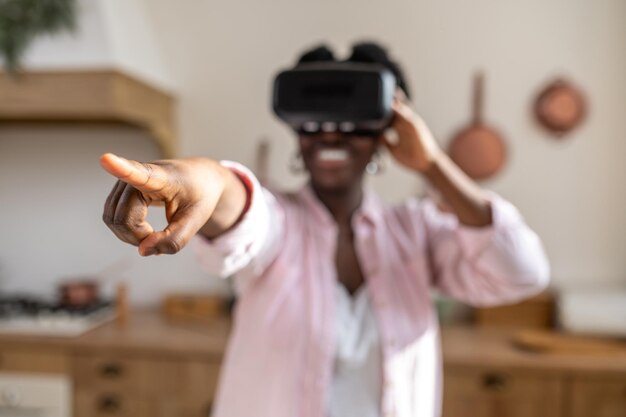 African woman in pink clothes in vr glasses looking excited