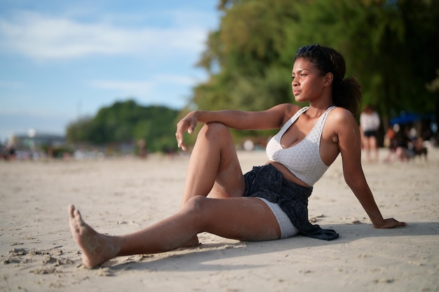 African woman sit on the beach Portrait sexy African lady travel ping and relaxing in the summer with tropical nature