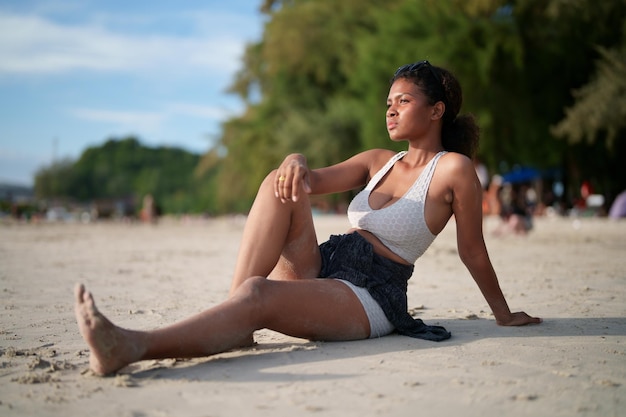 African woman sit on the beach Portrait sexy African lady travel ping and relaxing in the summer with tropical nature