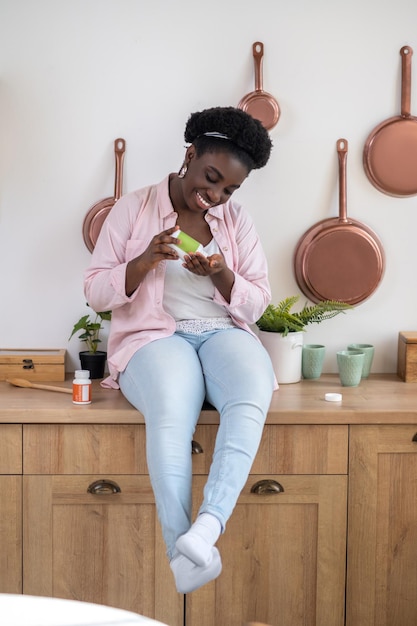 African woman sitting on the table with pills in hands