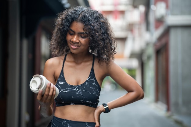 African woman sport healthy fit and firm slim drink water from cup on the hand athletic running wearing in the sportswear at city and town Fitness and sport motivation Runner concept