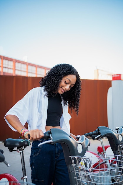 African woman taking a public bike in the city to be more eco friendly