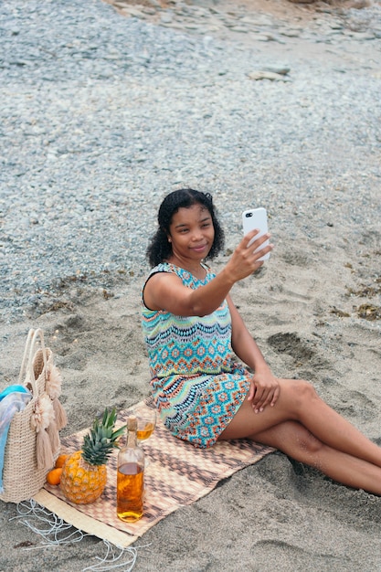 African Woman taking a selfie on the beach