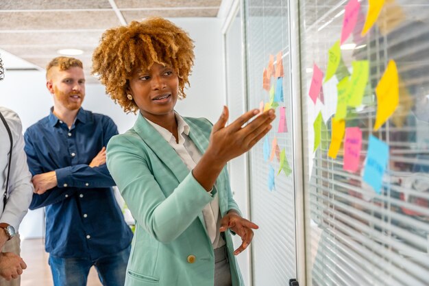 African woman using adhesive notes to explain a project