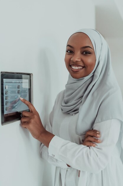 Photo african woman using a smart home screen control system. high-quality photo