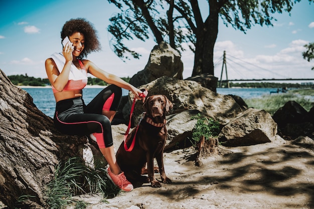 African Woman with Dog Talking on Phone.