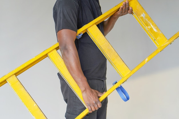 African worker with wooden ladder