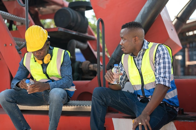 African workers Engineer Technician sitting and drinking water people resting after working