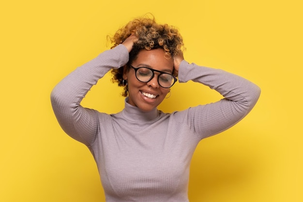 African young curly woman in eyeglasses enjoying good positive news