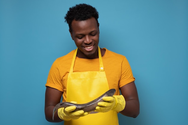 African young man in yellow apron with whole salmon fish