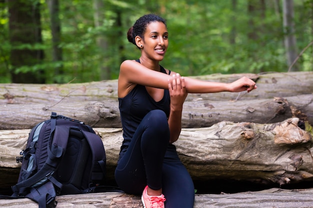 African young woman hiking on forest track 