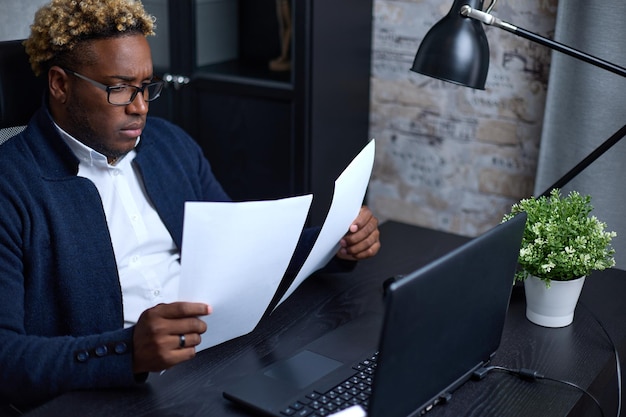 AfricanAmerican businessman holding accounting documents in his hands