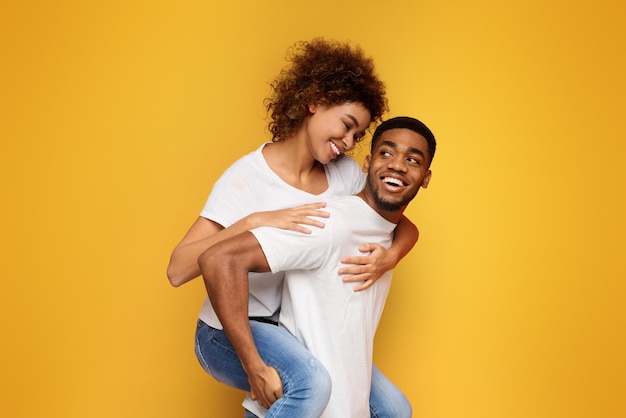 Africanamerican couple having fun on orange background