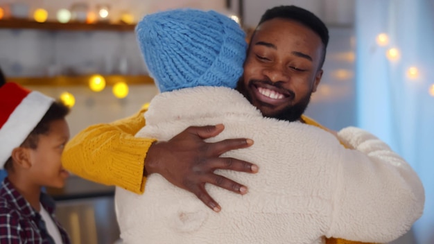 AfricanAmerican family welcome and hug friend coming to celebrate christmas together