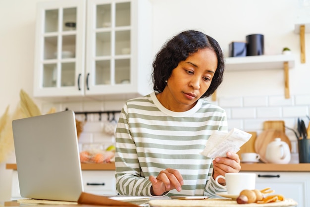 Photo africanamerican female paying bills dealing with accountancy on smartphone remote bookkeeping