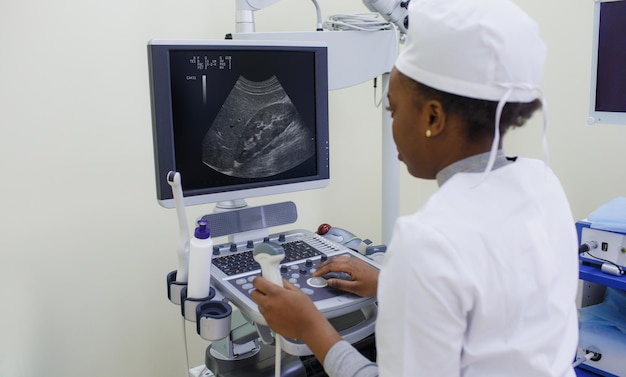 An AfricanAmerican girl doctor sits behind a new upgraded ultrasound machine for body organs