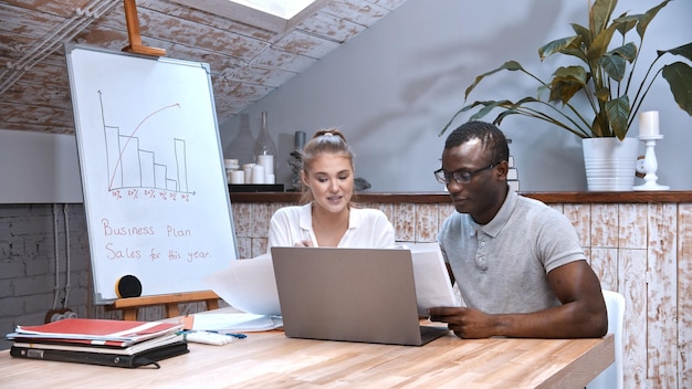 Africanamerican man and caucasian woman at the business meeting in bright office