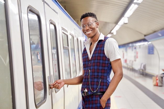 AfricanAmerican man opening train door looking into camera while smiling