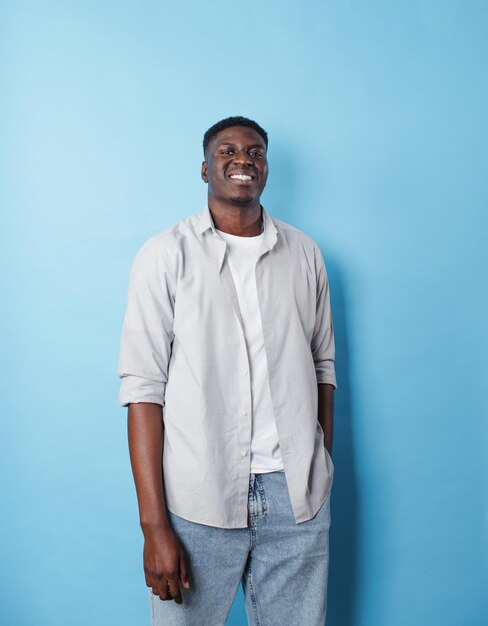 An AfricanAmerican man in white clothes stands on an isolated blue background