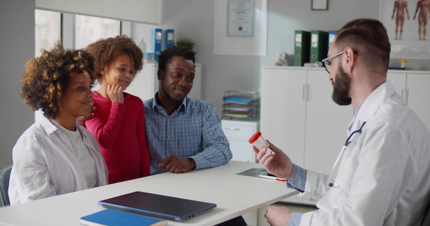 AfricanAmerican parents with little daughter visiting doctor in clinic