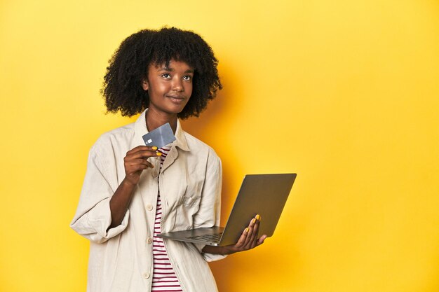 Photo africanamerican teen with laptop and credit card ready for online shopping