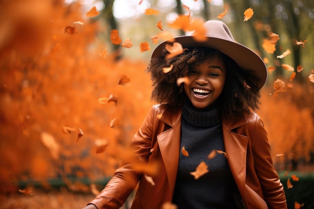 An africanamerican woman in a hat walks through the park as yellow leaves fall from the trees