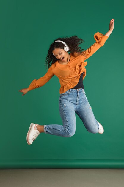 Africanamerican woman portrait isolated on green studio background with copyspace