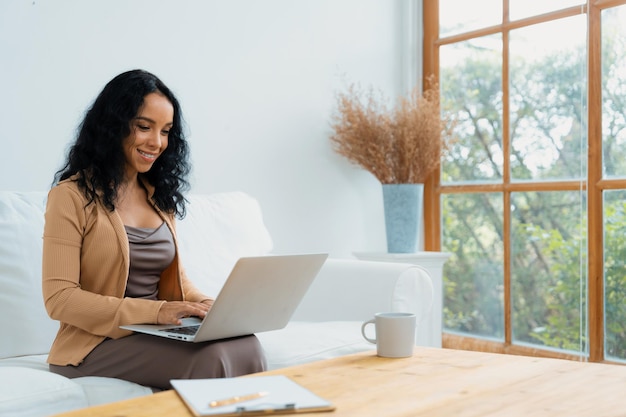 Photo africanamerican woman using laptop computer for crucial work on internet secretary or online content writing working at home