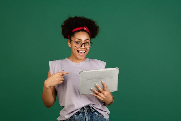 Africanamerican womans portrait isolated on green studio background with copyspace