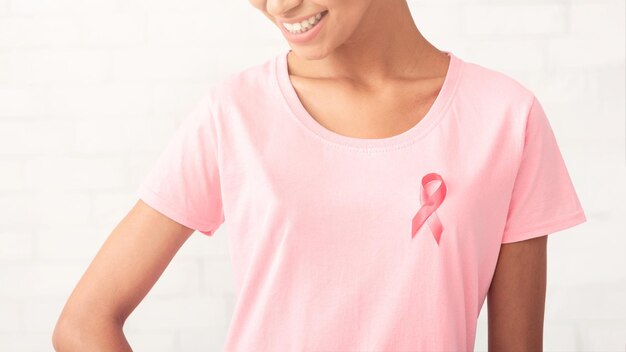 Afrikaans meisje met roze lint op T-shirt op witte achtergrond