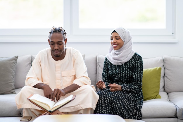 Afrikaans moslimpaar thuis in ramadan dat koran hulst islamboek leest
