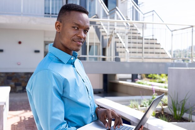 Afrikaanse Amerikaanse man interactie met laptop op buiten balkon planters relings kopieer ruimte
