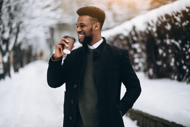 Afrikaanse Amerikaanse mens met koffie in openlucht in de winter