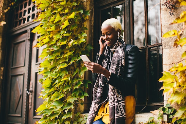 Afrikaanse Amerikaanse vrouw met smartphone openlucht