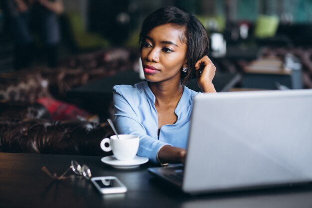 Afrikaanse Amerikaanse zakenvrouw met laptop in een café