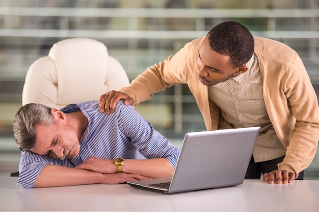 Afrikaanse arbeider die zijn slaap hogere collega wekt.